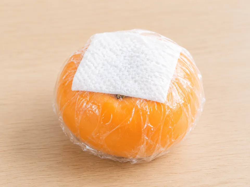 ヘタに濡らしたキッチンペーパーを当ててラップで包んだ柿